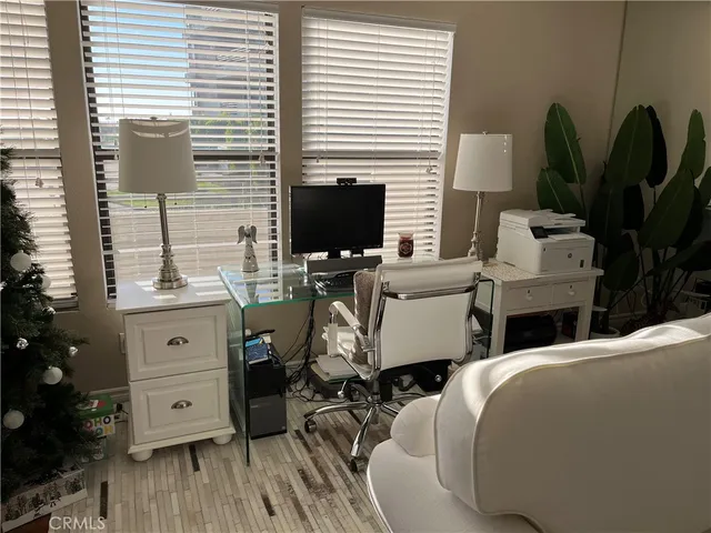 a view of a workspace with furniture and a window
