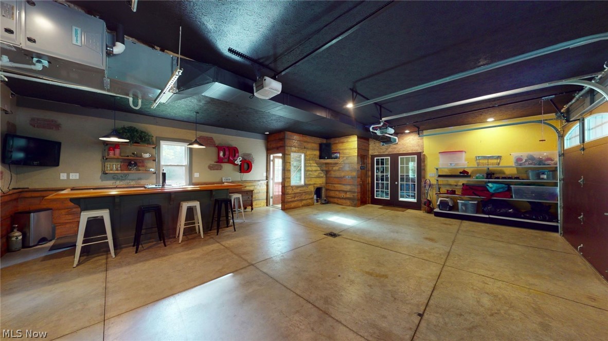 6556 Stone Road Hudson, OH 44236 - Photo 30 of 35 The man cave is located in the barn that has space to hold up to 6 vehicles. The space is divided by french doors. 1/2 bath, drain, water, and separate furnace and AC