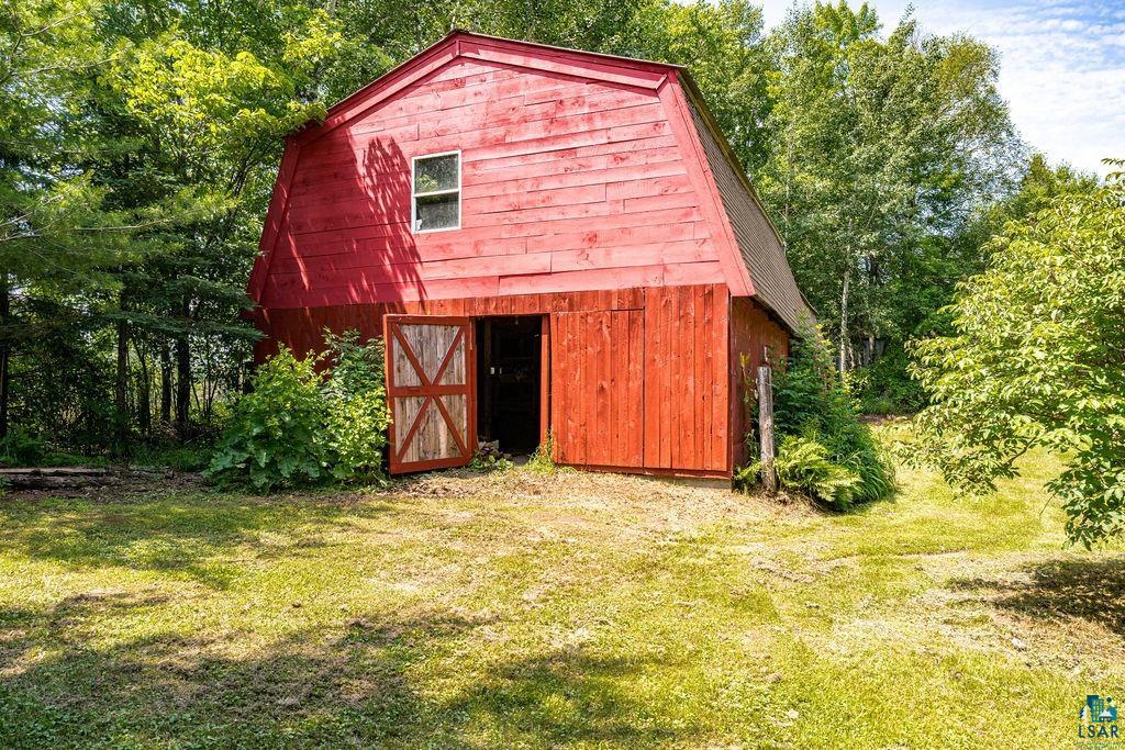 2592 Strandberg Road Barnum, MN 55707 - Photo 15 of 44 Red barn structure with a gambrel roof and natural wood sliding doors