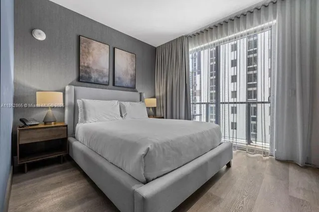 a large bed sitting in a bedroom next to a window