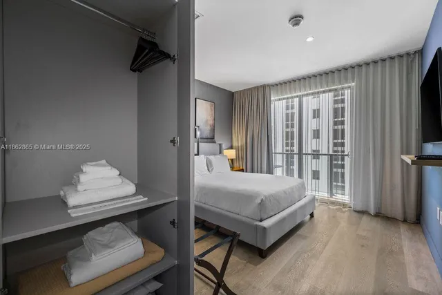 a bedroom with a bed and a flat tv screen on wall