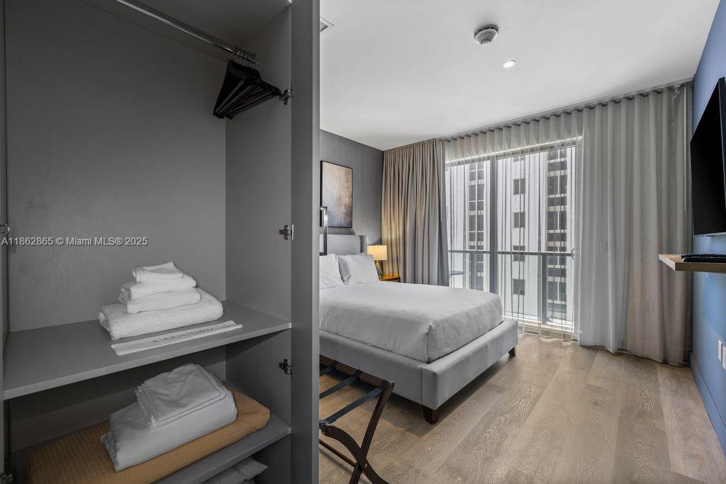 239 Southwest 9th Street, Unit 602 Miami, FL 33130 - Photo 13 of 18 a bedroom with a bed and a flat tv screen on wall