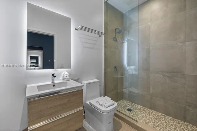 a bathroom with a sink a toilet and shower