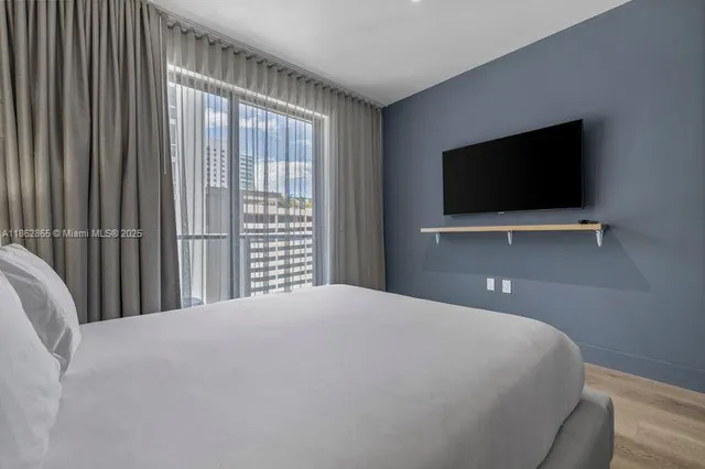 a bedroom with a bed and a flat screen tv