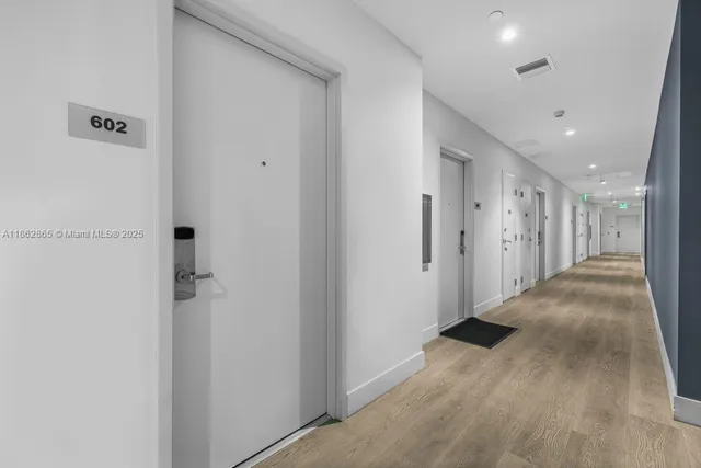 a view of a hallway with wooden floor
