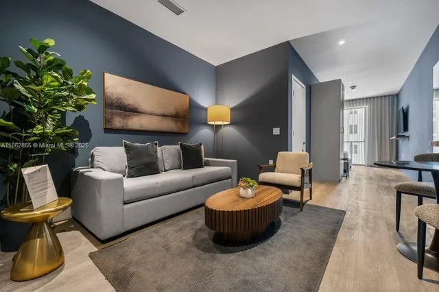 a living room with furniture and a potted plant