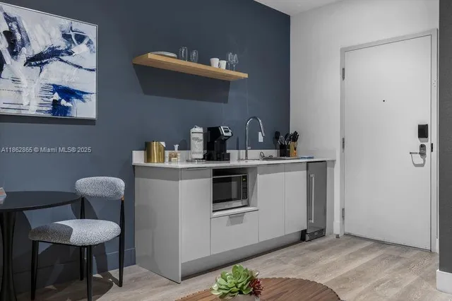 a kitchen with cabinets and chair