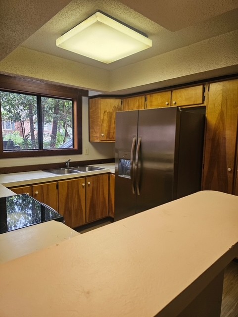 114 Houston Street Clemson, SC 29631 - Photo 4 of 19 Warm wood cabinetry and an integrated breakfast bar frame this functional kitchen design.