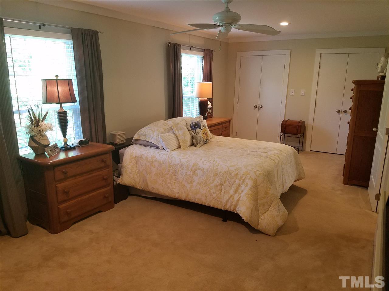 8412 Two Courts Drive Raleigh, NC 27613 - Photo 17 of 25 a bedroom with a bed and wooden floor