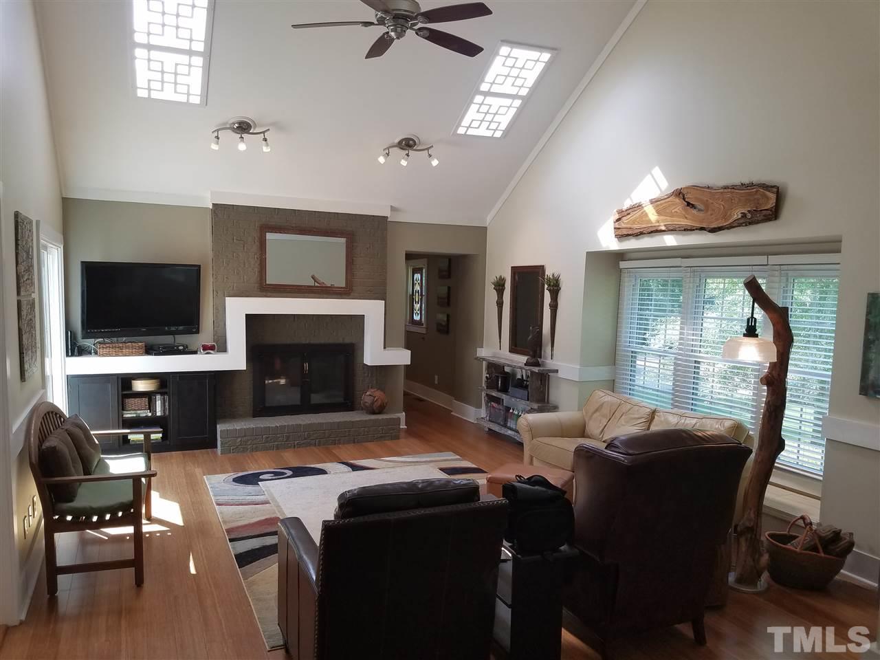 8412 Two Courts Drive Raleigh, NC 27613 - Photo 8 of 25 a living room with furniture a flat screen tv and kitchen view