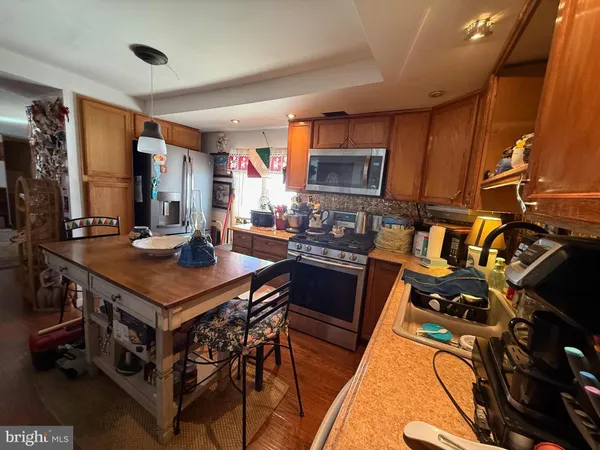 a kitchen with a stove a refrigerator and a dining table