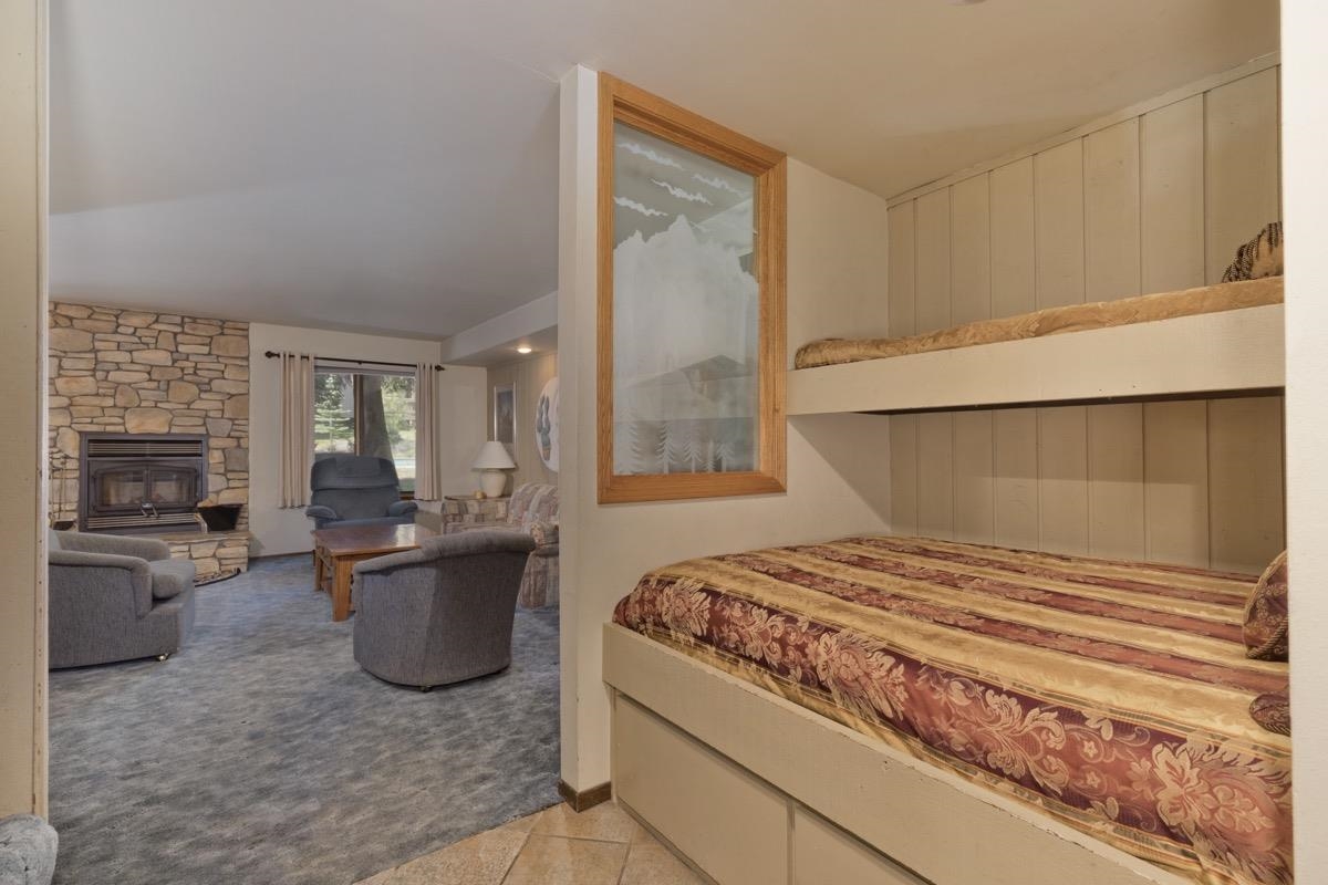 244 Lakeview Boulevard, Unit 149 Mammoth Lakes, CA 93546 - Photo 13 of 29 Bedroom featuring a fireplace, light colored carpet, and light tile patterned floors