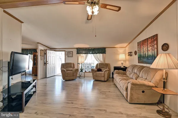 a living room with furniture flat screen tv and wooden floor