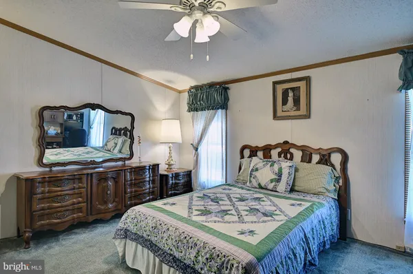 a bedroom with a bed a dresser and potted plants