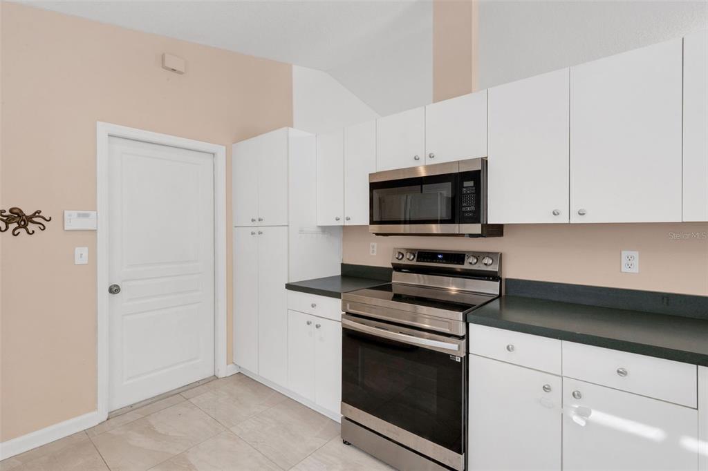 4557 Worcester Road Sarasota, FL 34231 - Photo 18 of 50 a kitchen with white cabinets and stainless steel appliances