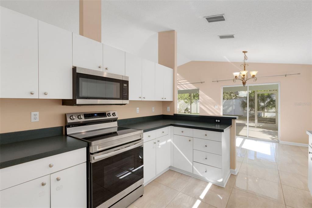 4557 Worcester Road Sarasota, FL 34231 - Photo 19 of 50 a kitchen with granite countertop a sink a stove and cabinets