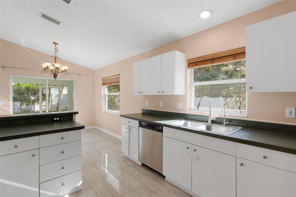 4557 Worcester Road Sarasota, FL 34231 - Photo 20 of 50 a kitchen with granite countertop white cabinets white appliances and a large window