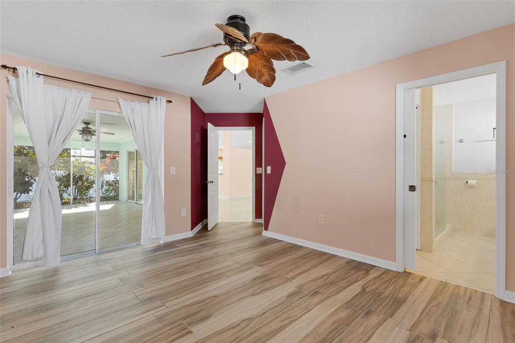 4557 Worcester Road Sarasota, FL 34231 - Photo 24 of 50 a view of empty room with wooden floor and fan