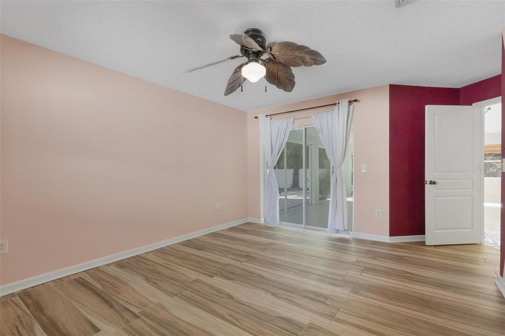 4557 Worcester Road Sarasota, FL 34231 - Photo 25 of 50 a view of empty room with wooden floor and fan
