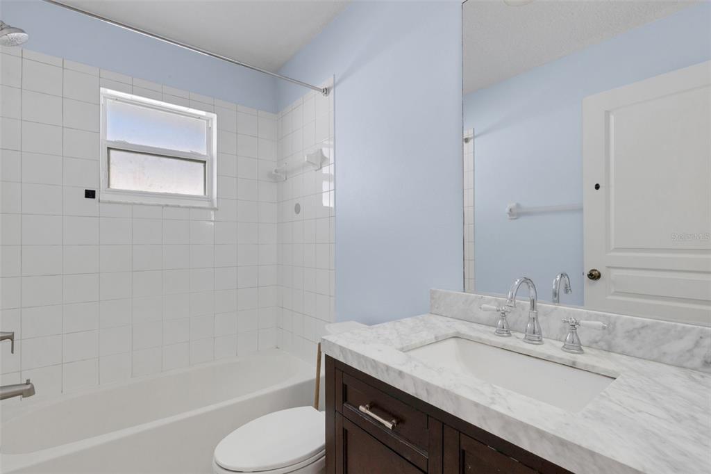 4557 Worcester Road Sarasota, FL 34231 - Photo 33 of 50 a bathroom with a granite countertop sink toilet and shower