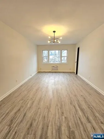 a view of a room with wooden floor and a window