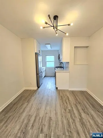 a view of a kitchen with wooden floor electronic appliances and window
