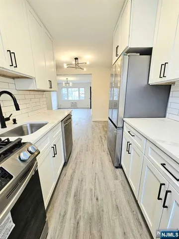 a kitchen with a sink a refrigerator and cabinets