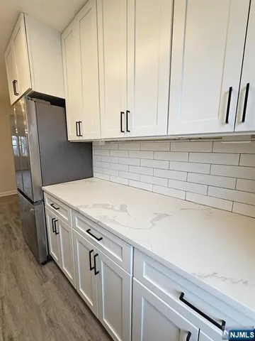 a kitchen with stainless steel appliances granite countertop a sink a refrigerator and a stove