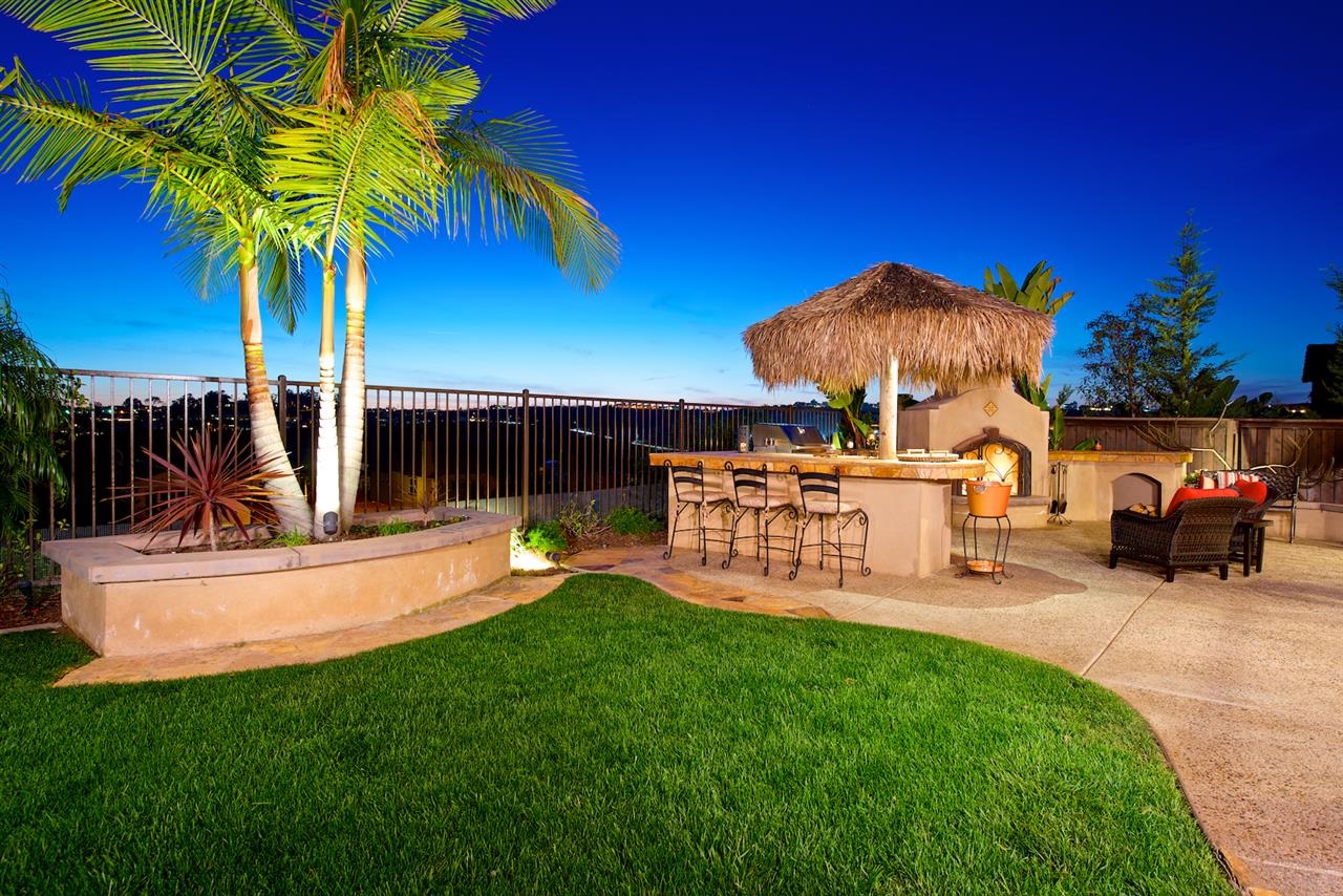 2436 Lapis Road Carlsbad, CA 92009 - Photo 22 of 25 The idyllic yard also features a covered veranda, woodburning fireplace, BBQ cook center with Palapa bar, grassy area, and mature tropical landscaping