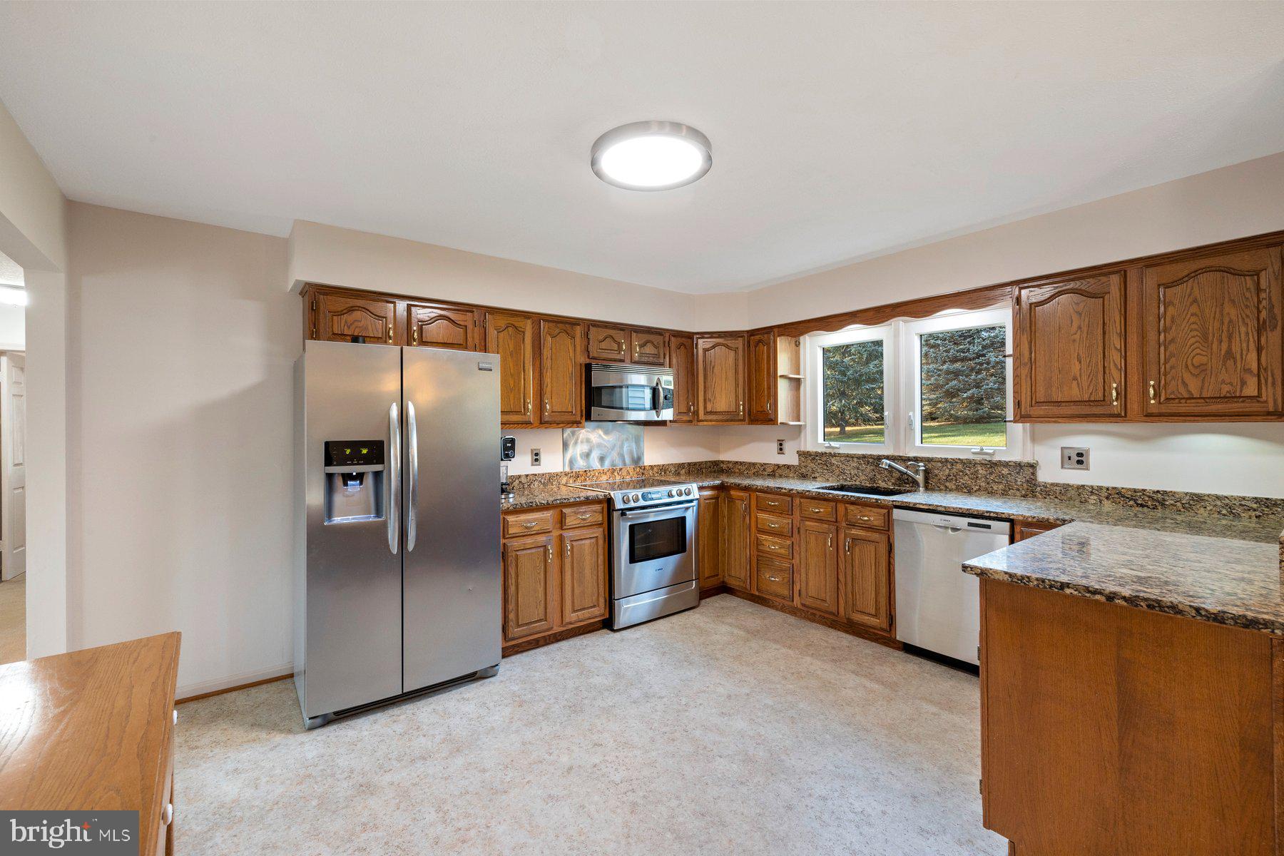 5130 Perry Road Mount Airy, MD 21771 - Photo 4 of 46 a large kitchen with granite countertop a stove top oven a sink dishwasher a refrigerator and cabinets