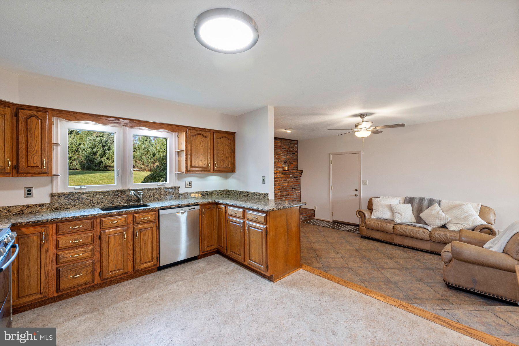 5130 Perry Road Mount Airy, MD 21771 - Photo 5 of 46 a large living room with stainless steel appliances granite countertop a sink dishwasher a stove and a refrigerator with wooden floor