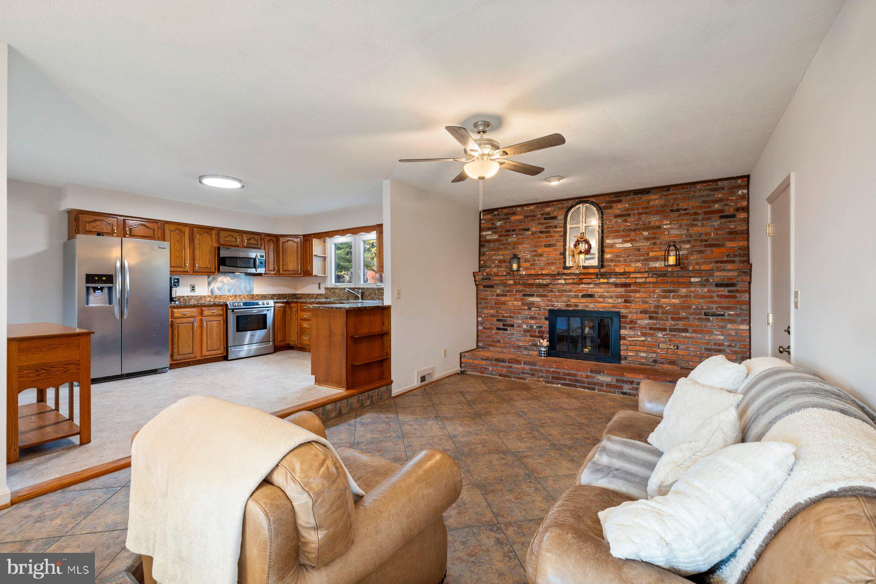 5130 Perry Road Mount Airy, MD 21771 - Photo 10 of 46 a living room with furniture a fireplace and kitchen view