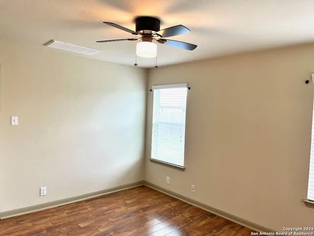 an empty room with a window and a ceiling fan