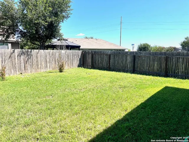 a view of a backyard with wooden fence