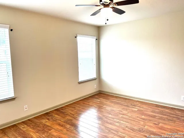 an empty room with a window and a ceiling fan