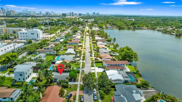 an aerial view of city and lake with trees all around