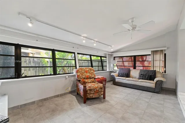 a living room with furniture flat screen tv and a large window