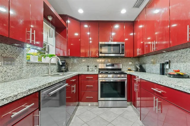 a kitchen with stainless steel appliances granite countertop a sink stove and cabinets
