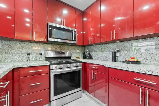 a kitchen with stainless steel appliances granite countertop wooden cabinets stove top oven and microwave