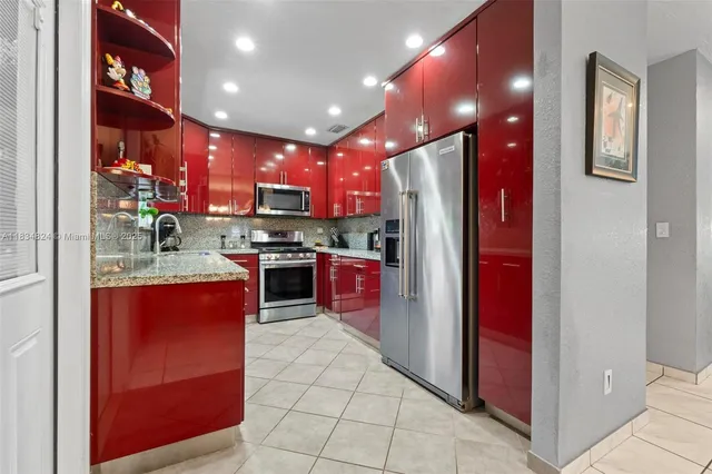 a kitchen with stainless steel appliances granite countertop a refrigerator and a sink