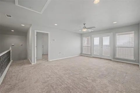 an empty room with windows and ceiling fan