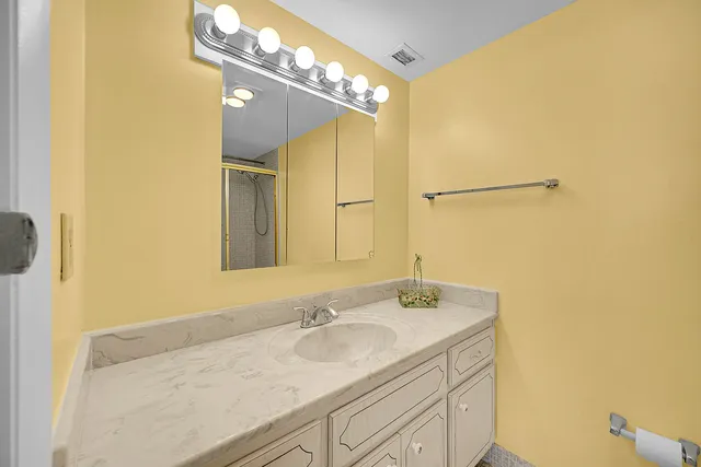 a bathroom with a granite countertop sink and a mirror