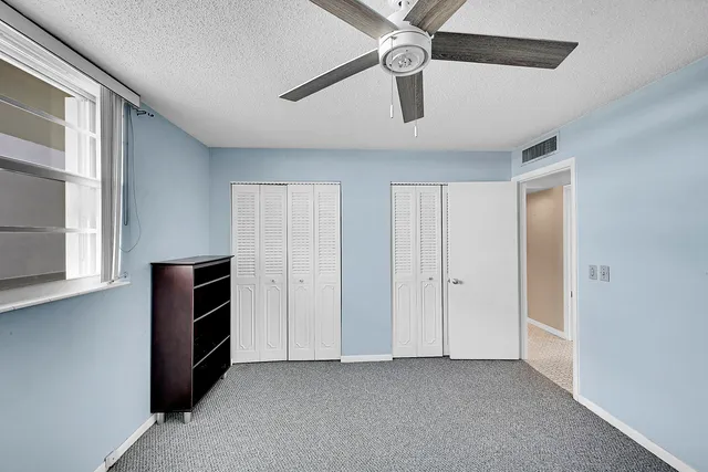 an empty room with closet and windows