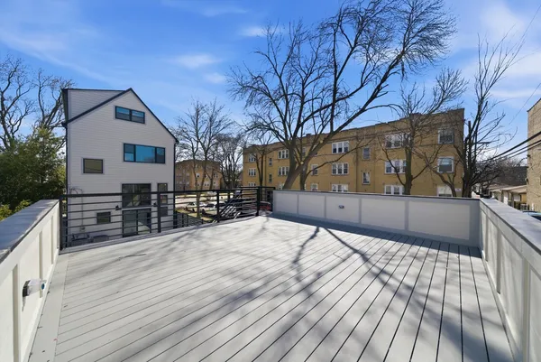 a view of backyard with large trees and wooden fence