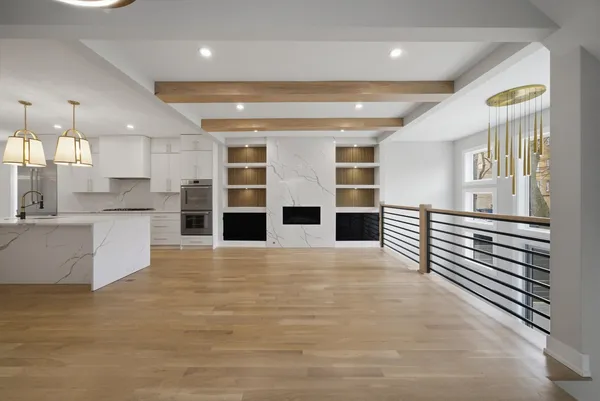 a view of a kitchen with stainless steel appliances wooden floor and windows