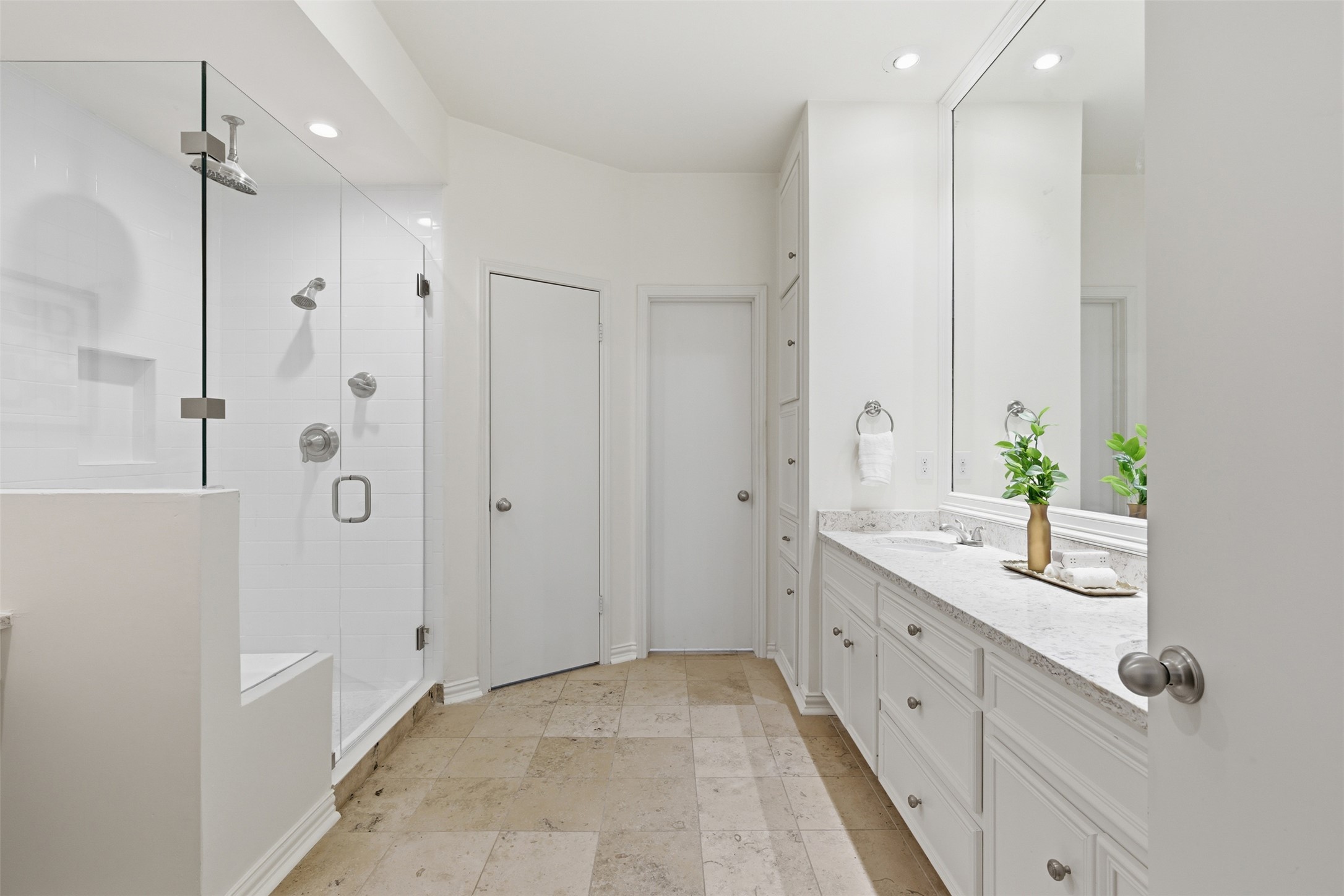 8101 Raintree Place Austin, TX 78759 - Photo 16 of 36 a spacious bathroom with a double vanity sink a large mirror and a shower