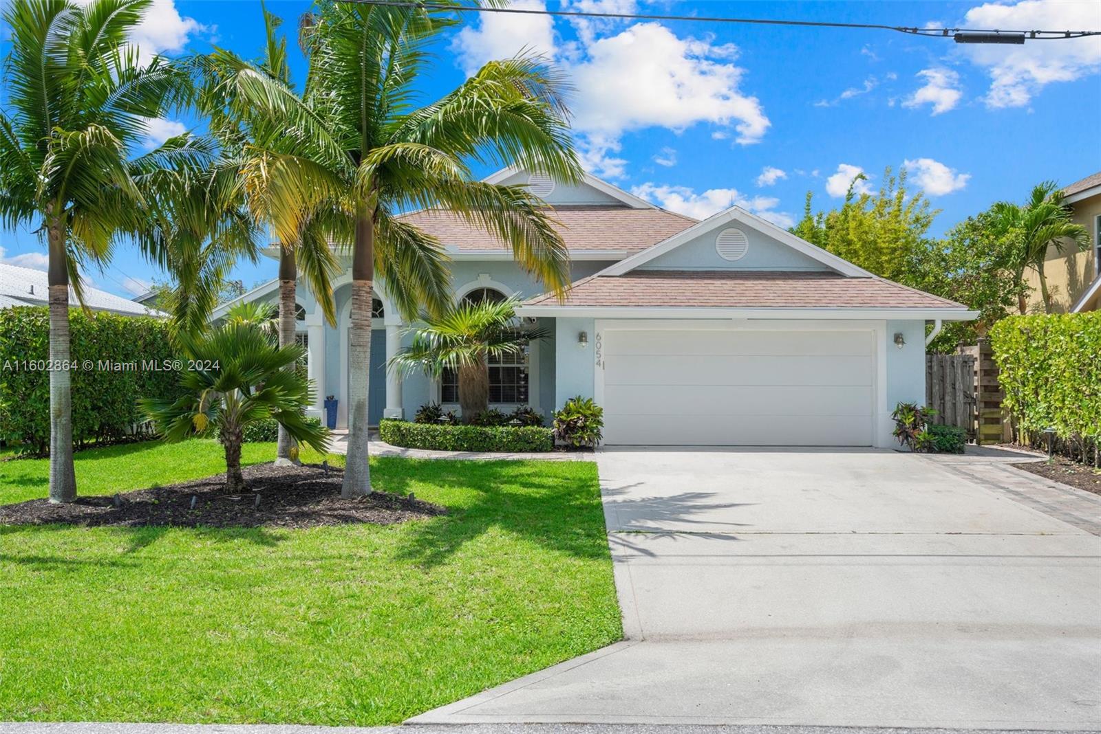 6054 Foster Street Jupiter, FL 33458 - Photo 1 of 50 a front view of a house with a yard and potted plants