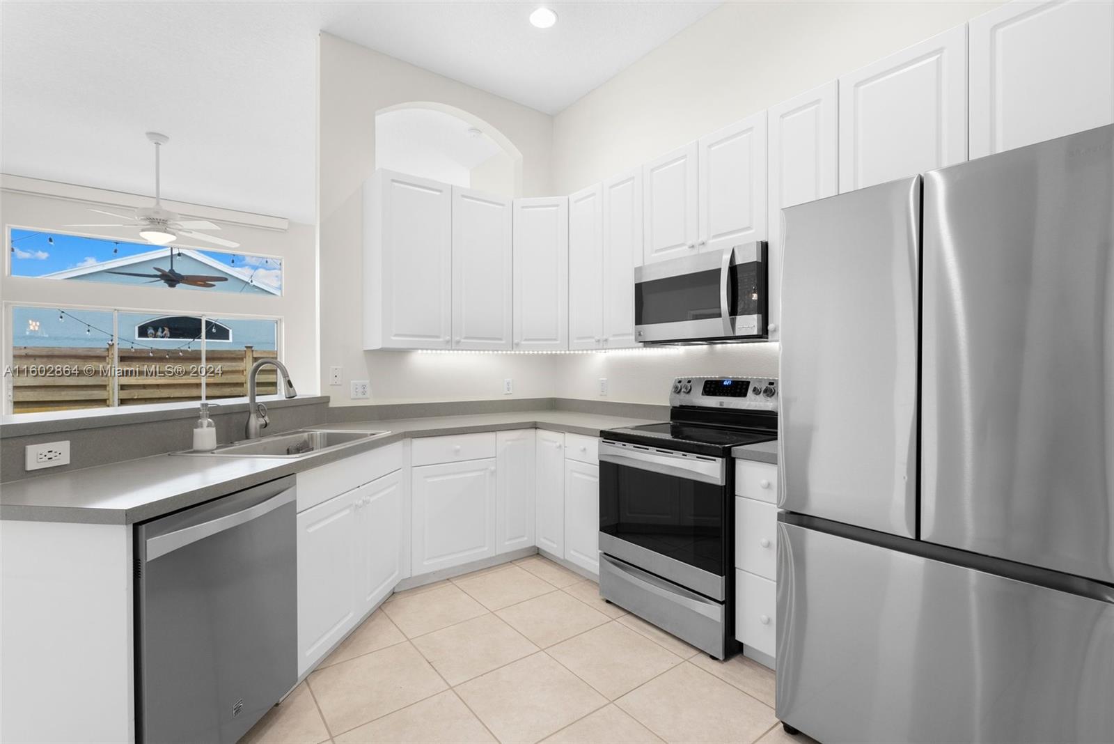 6054 Foster Street Jupiter, FL 33458 - Photo 18 of 50 a kitchen with stainless steel appliances granite countertop a refrigerator sink and stove