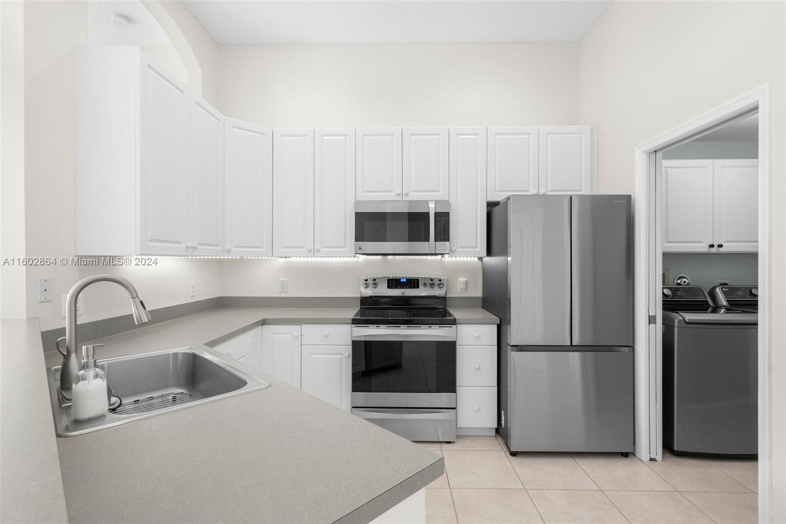 6054 Foster Street Jupiter, FL 33458 - Photo 19 of 50 a kitchen with granite countertop a stainless steel appliances a refrigerator and a sink