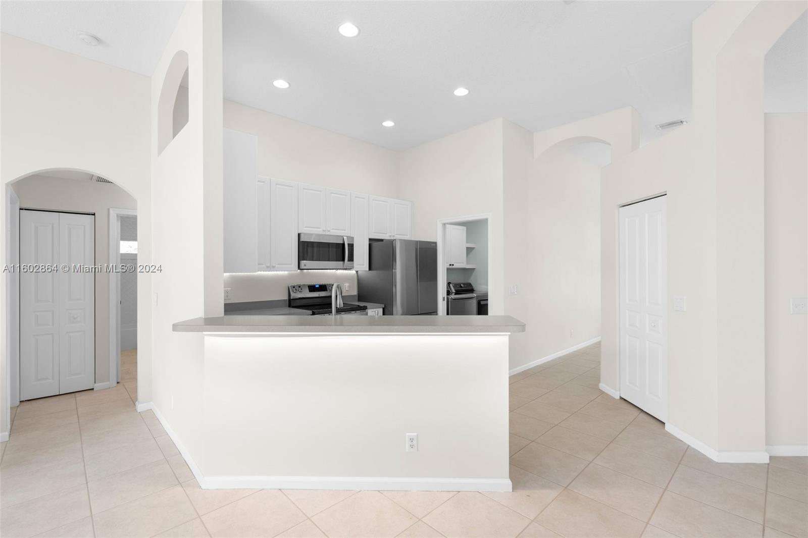 6054 Foster Street Jupiter, FL 33458 - Photo 20 of 50 a large kitchen with stainless steel appliances a refrigerator a stove and a sink